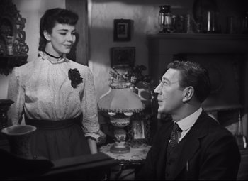 Movie still from “Cluny Brown” (1946), directed by Ernst Lubitsch – An old photo of a man and a woman sitting at a table; Medium shot, Over the shoulder angle