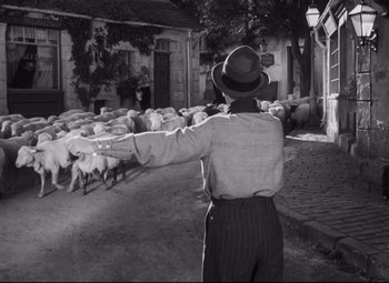 Movie still from “Cluny Brown” (1946), directed by Ernst Lubitsch – A black and white photo of a man herding a flock of sheep; Wide shot, High angle