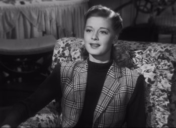 Movie still from “Cluny Brown” (1946), directed by Ernst Lubitsch – A black and white photo of a woman sitting on a couch; Medium shot, High angle