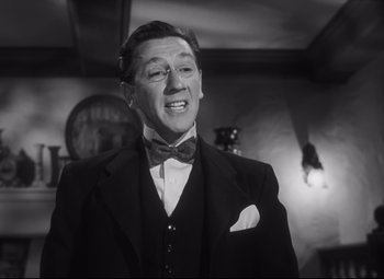 Movie still from “Cluny Brown” (1946), directed by Ernst Lubitsch – A man in a suit and bow tie; Close Up shot, Low angle