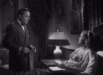 Movie still from “Cluny Brown” (1946), directed by Ernst Lubitsch – A man and a woman sitting on a bed in front of a lamp; Medium shot, Low angle