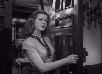 Movie still from “Cluny Brown” (1946), directed by Ernst Lubitsch – A black and white photo of a woman opening a door; Medium shot, Low angle