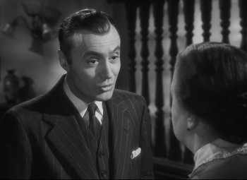 Movie still from “Cluny Brown” (1946), directed by Ernst Lubitsch – A man wearing a suit and tie talking to a woman; Close Up shot, High angle