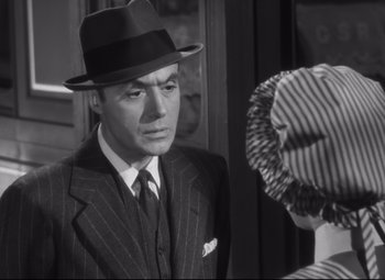 Movie still from “Cluny Brown” (1946), directed by Ernst Lubitsch – A man wearing a suit and a hat; Close Up shot, Over the shoulder angle