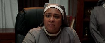 Movie still from “Cobra” (2022), directed by R. Ajay Gnanamuthu – A woman wearing a nun's outfit and a white head scarf; Close Up shot, Low angle