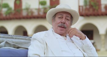 Movie still from “Cobra Verde” (1987), directed by Werner Herzog – An older man wearing a white suit and a white hat; Close Up shot, Low angle