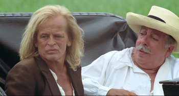 Movie still from “Cobra Verde” (1987), directed by Werner Herzog – A man and a woman sitting next to each other; Close Up shot, Over the shoulder angle