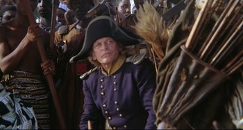 Movie still from “Cobra Verde” (1987), directed by Werner Herzog – An old man in a uniform and a hat; Medium shot, High angle