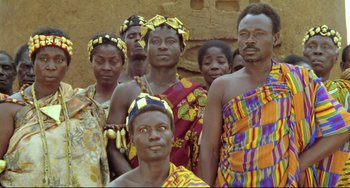Movie still from “Cobra Verde” (1987), directed by Werner Herzog – A group of men in traditional african clothing; Medium shot, High angle
