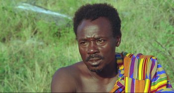 Movie still from “Cobra Verde” (1987), directed by Werner Herzog – A person with a beard; Close Up shot, High angle