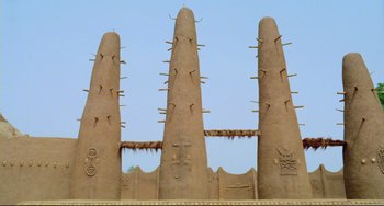 Movie still from “Cobra Verde” (1987), directed by Werner Herzog – A group of three tall towers made out of clay; Extreme Wide shot, Low angle