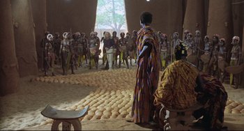 Movie still from “Cobra Verde” (1987), directed by Werner Herzog – A group of people standing in front of a group of people; Wide shot, High angle