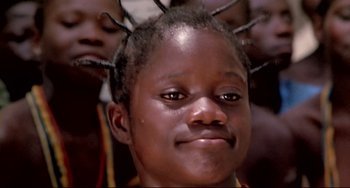 Movie still from “Cobra Verde” (1987), directed by Werner Herzog – A person with a bunch of hair; Close Up shot, Low angle