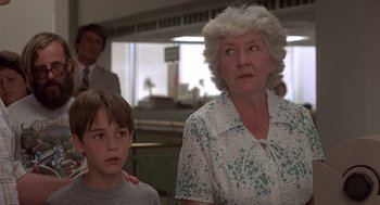 Movie still from “Cocoon” (1985), directed by Ron Howard – An older woman standing next to a young boy; Close Up shot, Low angle
