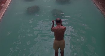 Movie still from “Cocoon” (1985), directed by Ron Howard – A man standing in the middle of a body of water; Wide shot, Overhead angle