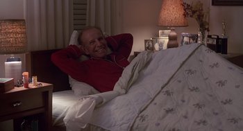 Movie still from “Cocoon” (1985), directed by Ron Howard – An older man laying in a bed listening to music; Medium shot, High angle