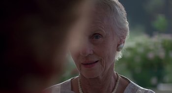 Movie still from “Cocoon” (1985), directed by Ron Howard – An older woman with a necklace looking at the camera; Close Up shot, Over the shoulder angle