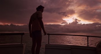 Movie still from “Cocoon” (1985), directed by Ron Howard – A man standing on the deck of a boat at sunset; Wide shot, Low angle