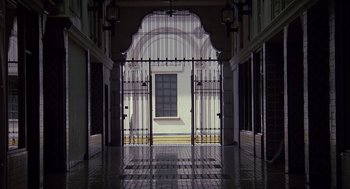 Movie still from “Cocoon” (1985), directed by Ron Howard – An open gate leading to a building with a large window; Extreme Wide shot, Low angle