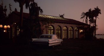 Movie still from “Cocoon” (1985), directed by Ron Howard – An old car parked in front of a building at night; Extreme Wide shot, Low angle