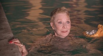 Movie still from “Cocoon” (1985), directed by Ron Howard – An older woman is swimming in the water; Close Up shot, High angle