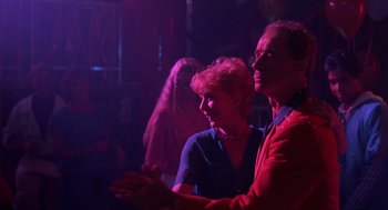 Movie still from “Cocoon” (1985), directed by Ron Howard – A man and a woman are standing in a dark room; Medium shot, Low angle