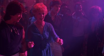 Movie still from “Cocoon” (1985), directed by Ron Howard – An older woman in a blue dress dancing in a club; Medium shot, Low angle