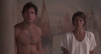 Movie still from “Cocoon” (1985), directed by Ron Howard – A man and a woman standing next to each other in front of a painting; Medium shot, Low angle