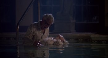 Movie still from “Cocoon” (1985), directed by Ron Howard – An old man and a young child in a pool of water at night; Medium shot, High angle