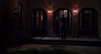 Movie still from “Cocoon” (1985), directed by Ron Howard – Two men are standing in front of a building at night; Wide shot, Low angle