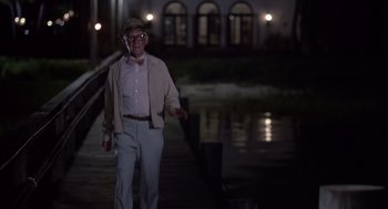 Movie still from “Cocoon” (1985), directed by Ron Howard – An older man standing on a dock at night; Wide shot, Low angle