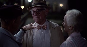 Movie still from “Cocoon” (1985), directed by Ron Howard – An older man wearing a hat and a bow tie; Close Up shot, Over the shoulder angle