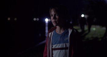 Movie still from “Cocoon” (1985), directed by Ron Howard – A young boy standing in the dark at night; Medium shot, Over the shoulder angle