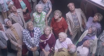 Movie still from “Cocoon” (1985), directed by Ron Howard – A group of older people standing around each other; Wide shot, High angle