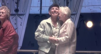 Movie still from “Cocoon” (1985), directed by Ron Howard – An older man and a younger woman kissing; Medium shot, Low angle