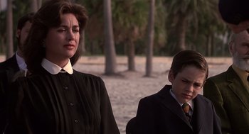 Movie still from “Cocoon” (1985), directed by Ron Howard – A woman standing next to a man in a suit; Medium shot, Over the shoulder angle
