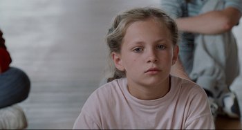 Movie still from “Code Unknown” (2000), directed by Michael Haneke – A young girl is sitting in front of a mirror; Close Up shot, Over the shoulder angle