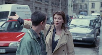 Movie still from “Code Unknown” (2000), directed by Michael Haneke – A man and a woman standing next to each other on the street; Medium shot, Over the shoulder angle