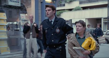 Movie still from “Code Unknown” (2000), directed by Michael Haneke – A man in a uniform walking down a street; Medium shot, Low angle