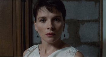 Movie still from “Code Unknown” (2000), directed by Michael Haneke – A person with short hair wearing a white dress; Close Up shot, High angle