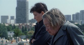 Movie still from “Code Unknown” (2000), directed by Michael Haneke – Two people standing next to each other on a roof top; Close Up shot, Low angle