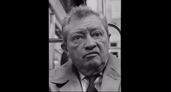 Movie still from “Code Unknown” (2000), directed by Michael Haneke – An older man in a suit and tie; Close Up shot, Low angle