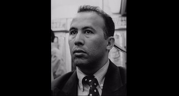 Movie still from “Code Unknown” (2000), directed by Michael Haneke – Black and white photograph of a man in a suit and tie; Close Up shot, Low angle