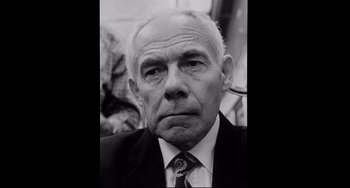 Movie still from “Code Unknown” (2000), directed by Michael Haneke – An older man wearing a suit and tie; Close Up shot, Low angle