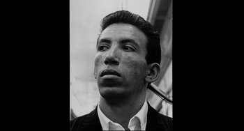 Movie still from “Code Unknown” (2000), directed by Michael Haneke – Black and white photograph of a man smoking a pipe; Close Up shot, Low angle