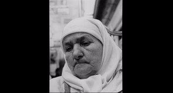 Movie still from “Code Unknown” (2000), directed by Michael Haneke – An old woman wearing a head scarf and a white head scarf; Close Up shot, Low angle