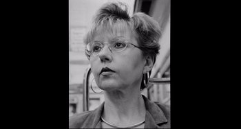 Movie still from “Code Unknown” (2000), directed by Michael Haneke – A black and white photo of a woman with glasses; Close Up shot, Low angle