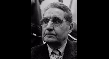 Movie still from “Code Unknown” (2000), directed by Michael Haneke – An older man wearing glasses and a suit; Close Up shot, Low angle