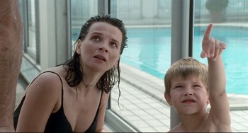 Movie still from “Code Unknown” (2000), directed by Michael Haneke – A woman and a boy sitting in front of a swimming pool; Close Up shot, High angle