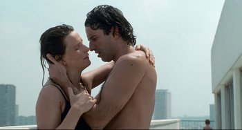Movie still from “Code Unknown” (2000), directed by Michael Haneke – A man and a woman embracing each other on the beach; Close Up shot, Overhead angle